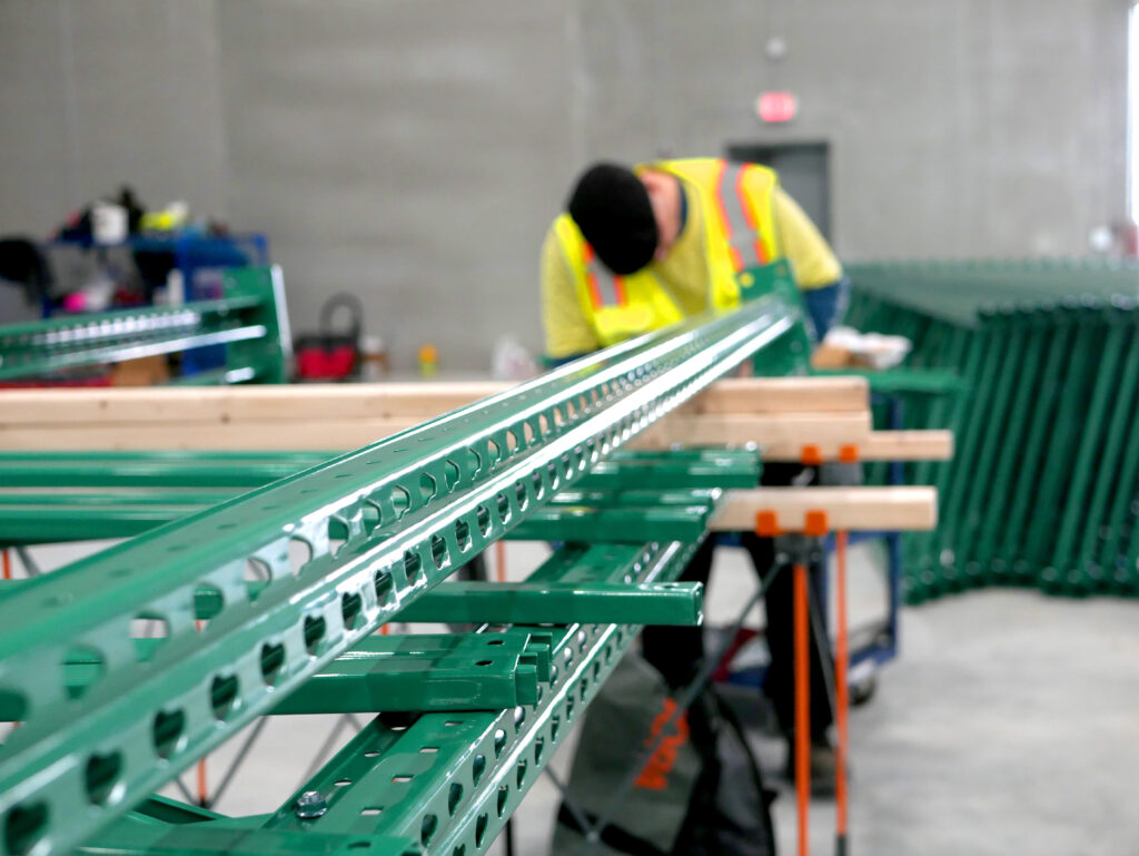 guy assembling new green rack upright